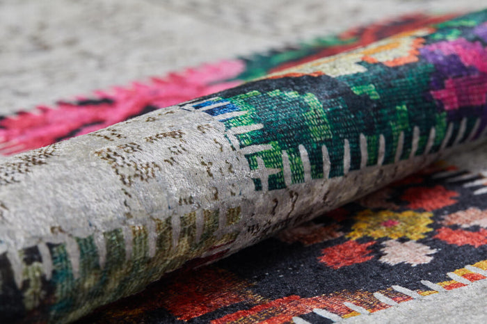 A close-up of the Blooming Paradise - Washable Rug - JR188 shows vibrant geometric and floral patterns in green, pink, red, and black on a textured background—perfect for stylish high-traffic spaces.