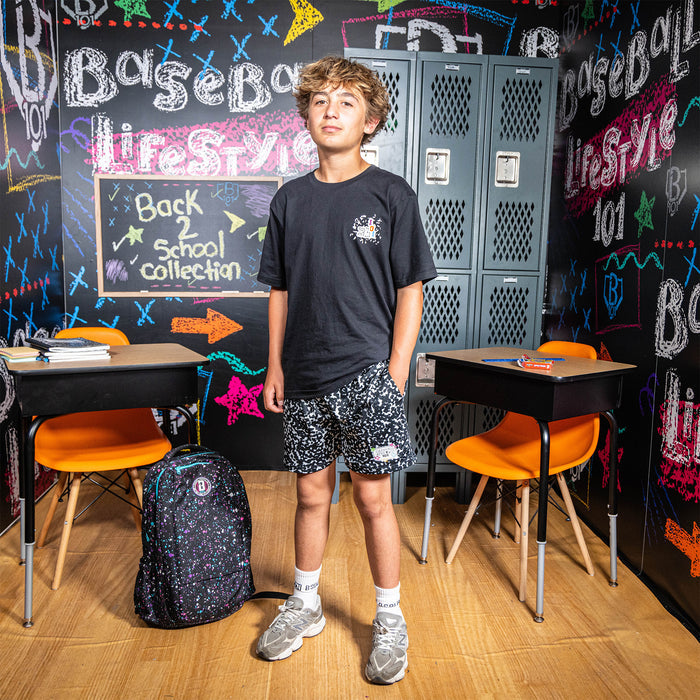 Adult model wearing black shorts with “Composition” design