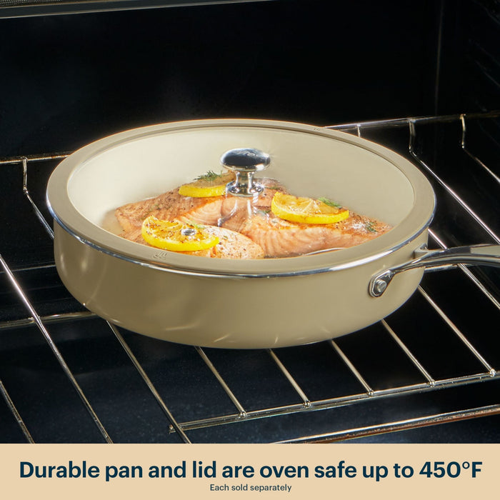 Beige ceramic cookware set with salmon dish inside an oven