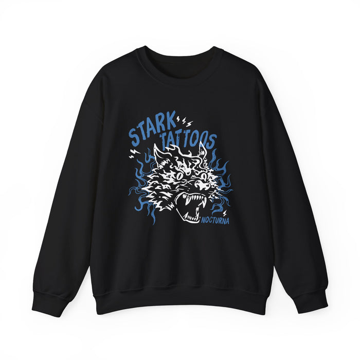 Wolves of Ruin collection by thtgrlreads features a black oversized crewneck sweatshirt from Printify with a vintage wash, showcasing a bold blue and white graphic of a snarling wolf surrounded by stylized flames and the words "Stark Tattoos.