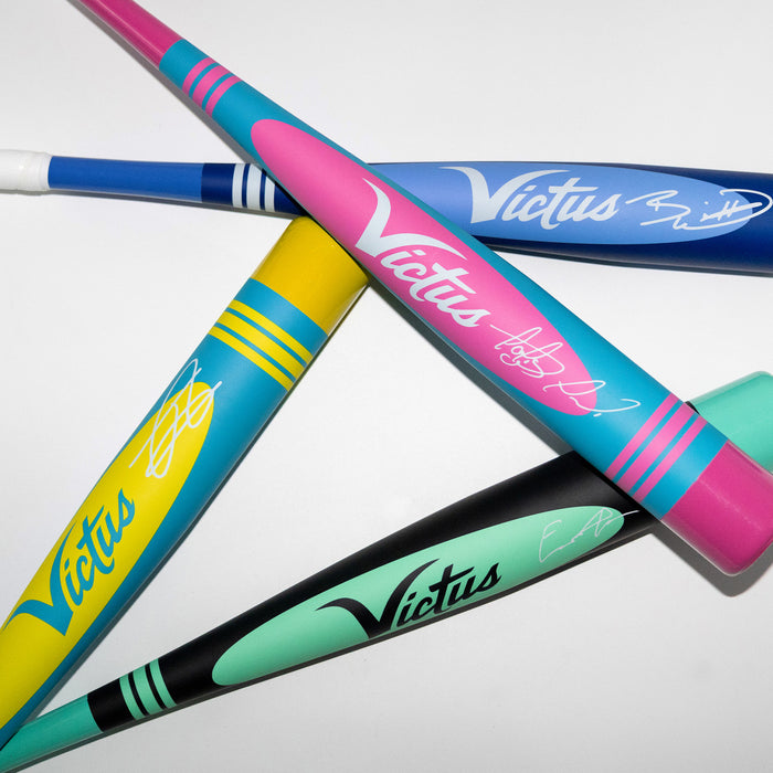 Three Victus 2025 Vibe Pro-Crayon Fernando Tatis Jr (-8) USSSA bats, each with signature style, crisscross on a white background. Vibrant blue, pink, yellow, teal, and black hues make these bats truly stand out.