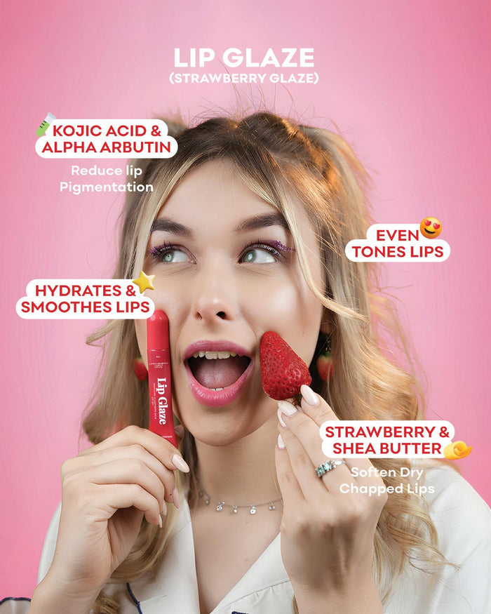 A woman with blonde hair holds a red Lip Glaze tube in one hand and a strawberry in the other, set against a solid pink background with text overlays describing the lip glaze benefits and flavor.