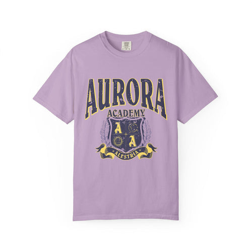 A vintage wash lilac Comfort Colors graphic tee from thtgrlreads featuring a distressed print of Aurora Academy with a crest emblem, part of the Ruthless Boys of the Zodiac and Back to School collections.