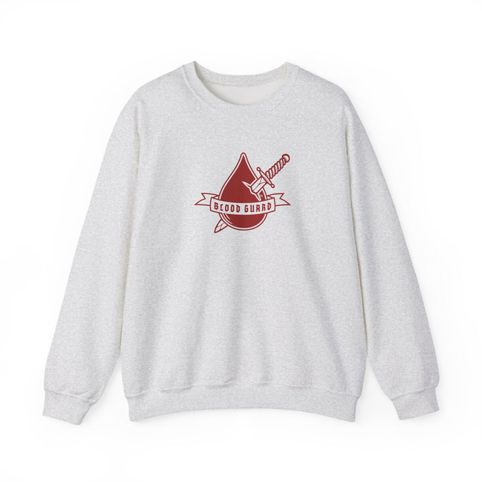 Thtgrlreads Bloodwing Academy crewneck featuring a vintage-washed Comfort Colors fabric with a bold red graphic of a dagger and blood drop with "Blood Guard" text, part of officially licensed bookish apparel collections.