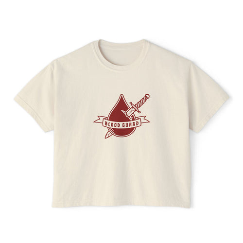 Thtgrlreads Bloodwing Academy crop top featuring a vintage-wash comfort colors fabric with a bold graphic of a blood drop and sword and "Blood Guard" banner in deep red, part of officially licensed bookish apparel collections.
