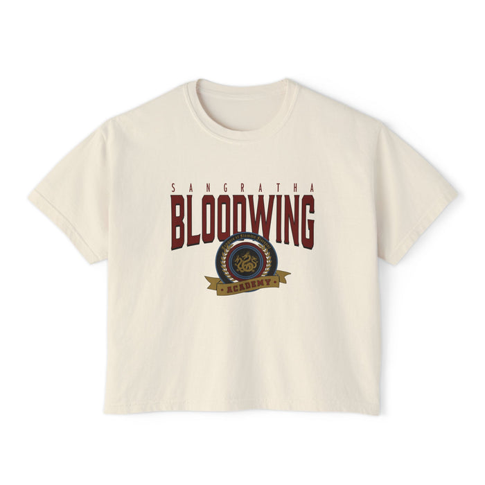A cream-colored unisex Comfort Colors cropped t-shirt featuring a vintage wash and bold Bloodwing Academy graphic text with a circular emblem in maroon and gold, thtgrlreads.
