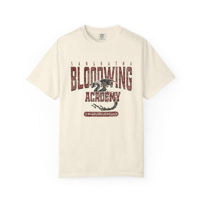 Cream Comfort Colors graphic tee from thtgrlreads featuring a vintage wash Bloodwing Academy design with a distressed dragon print, part of the Back to School and Tees collections.