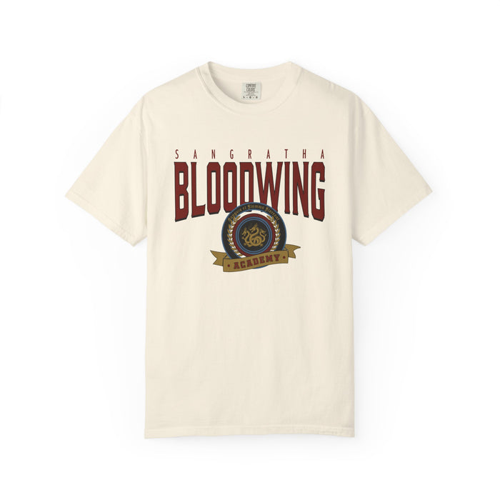 Officially licensed Bloodwing Academy Comfort Colors graphic tee by thtgrlreads featuring a vintage-style print with "Sangratha Bloodwing Academy" text and emblem on a cream unisex cotton shirt.