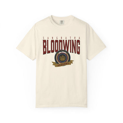 Officially licensed Bloodwing Academy Comfort Colors graphic tee by thtgrlreads featuring a vintage-style print with "Sangratha Bloodwing Academy" text and emblem on a cream unisex cotton shirt.