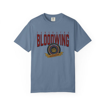 A vintage wash Comfort Colors graphic tee from thtgrlreads featuring Bloodwing Academy text and emblem in bold red and gold, part of the Back to School and Bloodwing Academy collections.