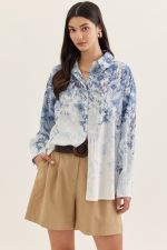 Blue flower blouse by Entro featuring a vibrant blue floral pattern and lightweight fabric, displayed on a hanger.
