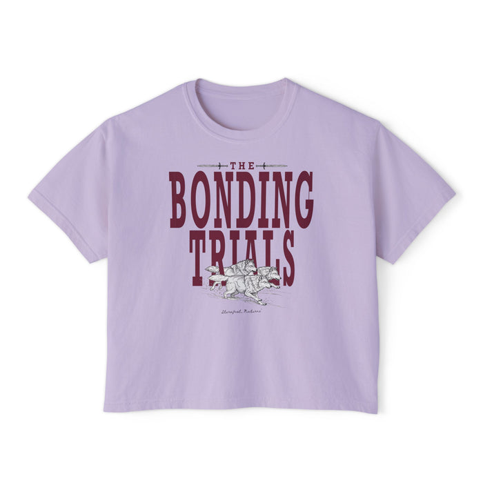 thtgrlreads Wolves of Ruin collection features a lavender Comfort Colors crop top with vintage wash, bold maroon "The Bonding Trials" text, and a detailed wolf graphic.
