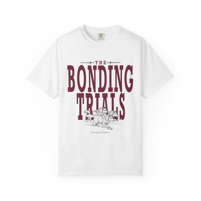 A white Comfort Colors graphic tee from thtgrlreads featuring vintage wash fabric and bold maroon "The Bonding Trials" text with an illustrated wolf design, part of Wolves of Ruin and Tees collections.