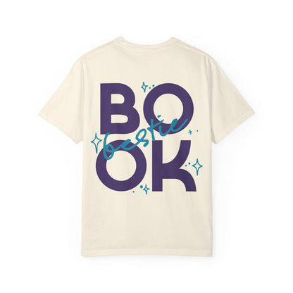 thtgrlreads Book Bestie collection comfort colors graphic tee with vintage washed cream fabric featuring bold navy "BOOK" lettering and teal cursive "bestie" overlay with star accents, unisex fit