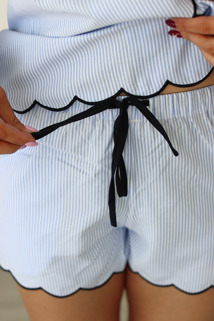 Close-up of a person wearing a blue and white striped pajama outfit with a black string.