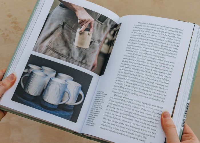 Open pottery book with color photos of cups on left page