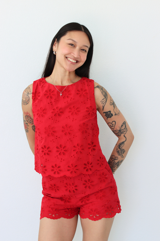 Woman wearing a red flower eyelet short set with a white background