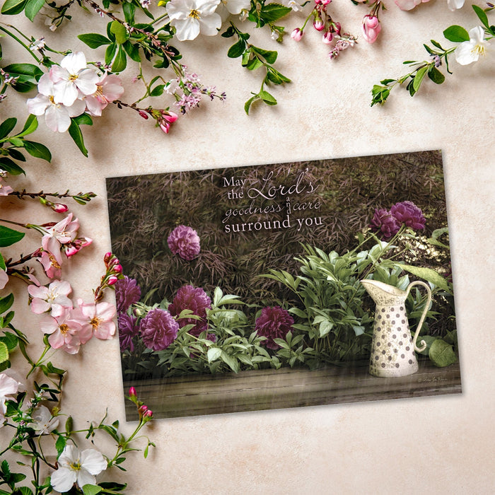 Decorative card with floral design and inspirational quote on a textured surface with flowers around.