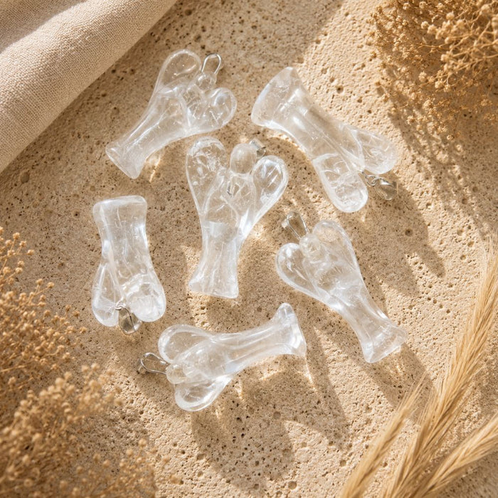 Clear Quartz Angel Pendant on a neutral stone background