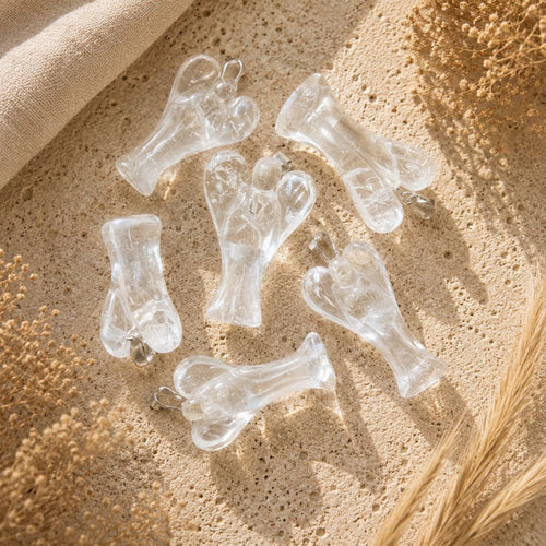 Clear Quartz Angel Pendant on a neutral stone background