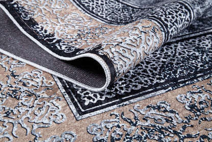 A close-up of the Contemporary Borderline - Washable Rug - JR1798 reveals its ornate beige and black flat weave, a folded corner highlighting intricate textures—an allergy-friendly, stylish addition perfect for any space.