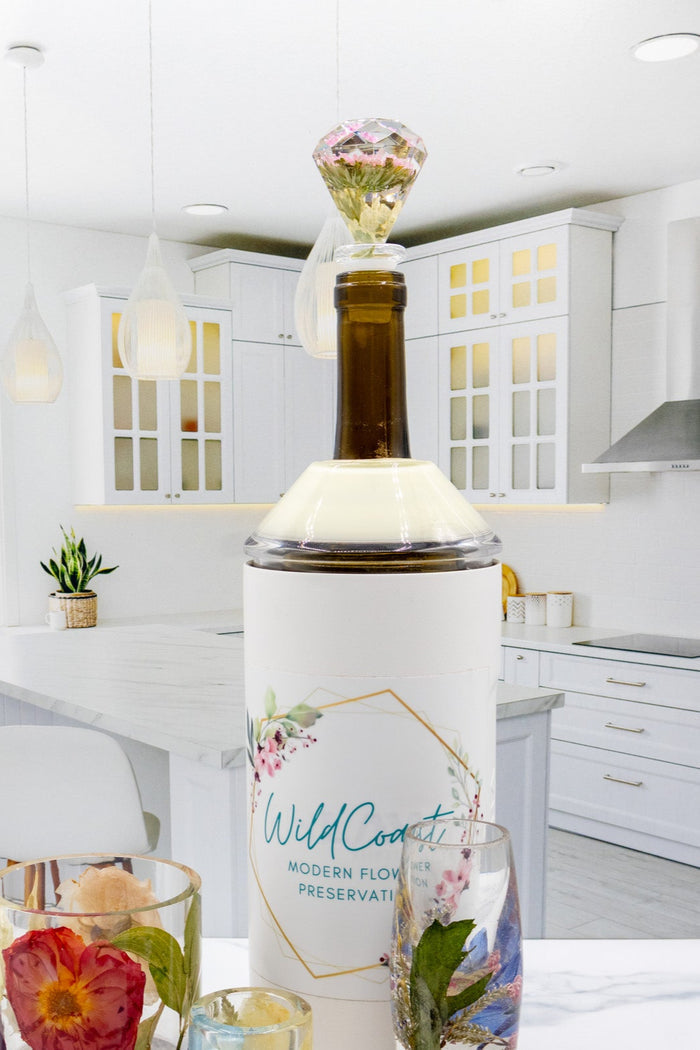Tall portrait photo of a pressed flower wine stopper with blush dried roses in clear resin