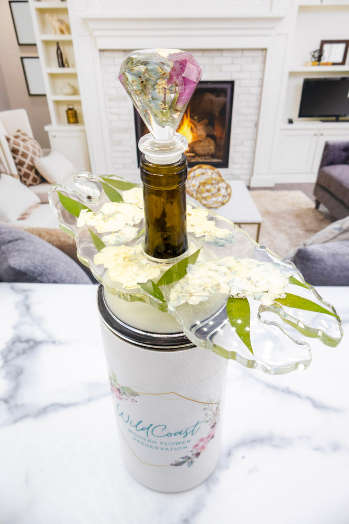 Tall portrait photo of a pressed flower wine stopper with soft dried roses in clear resin
