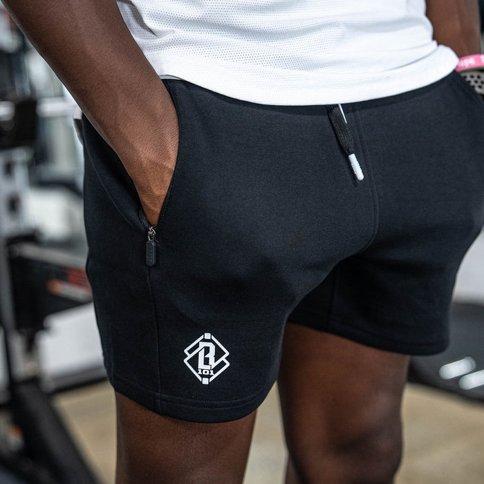 Person wearing black shorts with a BL101 logo on a blurred background