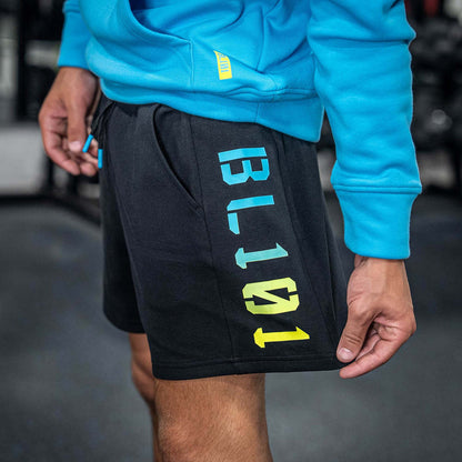 Person wearing black shorts with colorful BL101 text, standing in a gym setting.