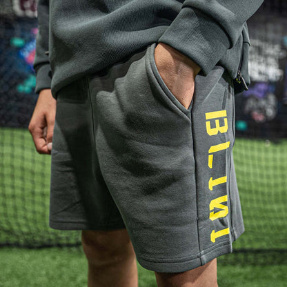 Person wearing gray shorts with 'BL101' text on a grassy field.