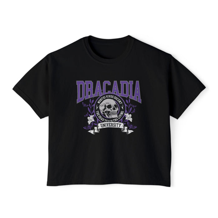 Nocticadia-themed crop top from thtgrlreads featuring vintage wash black Comfort Colors fabric with purple collegiate-style "Dracadia" text and skull graphic emblem, part of official licensed Tees collections.