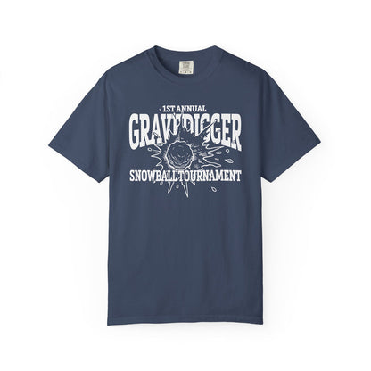 A vintage wash Comfort Colors graphic tee from thtgrlreads featuring a bold white print reading "1st Annual Gravedigger Snowball Tournament" with a snowball graphic, part of the Liv Zander and Tees collections.