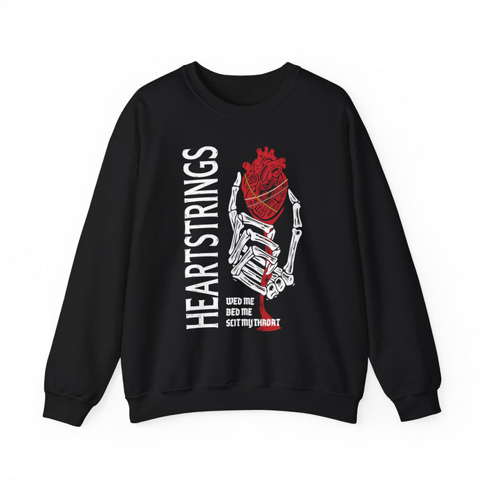 thtgrlreads Liv Zander collection oversized crewneck sweatshirt featuring a vintage-washed Comfort Colors base with a bold graphic of a skeletal hand holding a red anatomical heart and stylized text reading "HEARTSTRINGS" in white vertical letters.