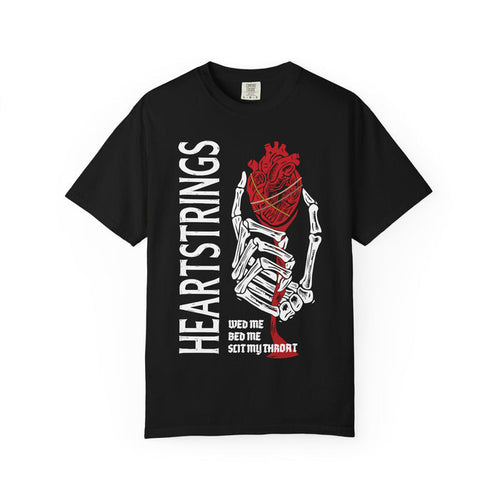 A black Comfort Colors graphic tee from thtgrlreads featuring Liv Zander-inspired design with a skeletal hand holding a detailed red anatomical heart and bold vertical "Heartstrings" text, perfect for romantasy fans in the Tees collection.