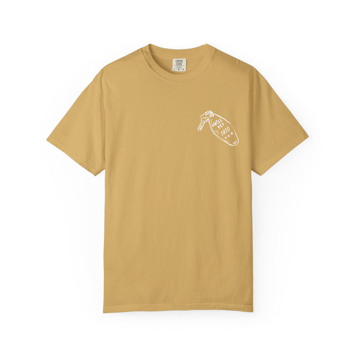 A vintage wash Comfort Colors graphic tee in mustard yellow from thtgrlreads, featuring a small white hand-drawn style print on the chest, part of the Tees and Hockey Romance collections.
