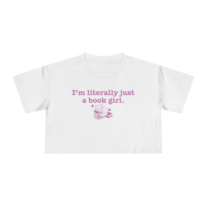 thtgrlreads officially licensed bookish apparel features this Printify white Comfort Colors crop top with vintage wash, soft fabric, and a purple graphic saying "I'm literally just a book girl" above a stack of books illustration, part of the Tees collection.