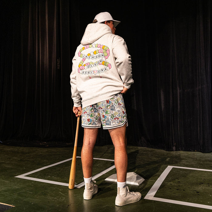Back view of the adult male model wearing the white Jackson Olson x BL101 Hometown Shorts paired with the BSBL Era hoodie showing the friendship bracelet back graphic
