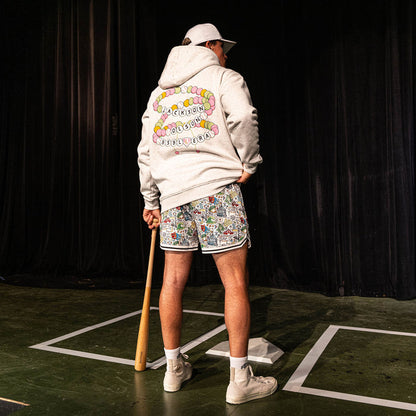 Back view of the adult male model wearing the white Jackson Olson x BL101 Hometown Shorts paired with the BSBL Era hoodie showing the friendship bracelet back graphic