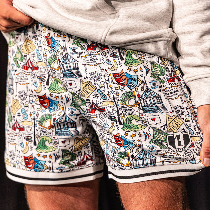 Close-up of the white Jackson Olson x BL101 Hometown Shorts highlighting the full all-over illustrated print, striped hem, and BL101 home plate logo