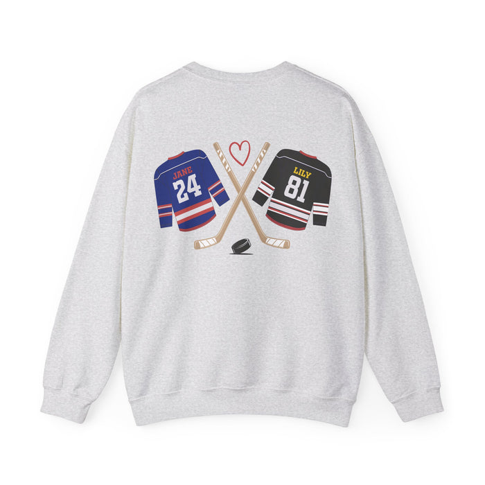 A thtgrlreads light gray Comfort Colors oversized crewneck sweatshirt from the Hockey Romance collection featuring a vintage graphic of crossed hockey sticks, a puck, and jerseys labeled "Jane 24" and "Lily 81" with a red heart above.