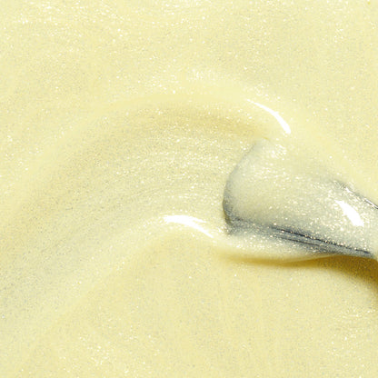 A close-up of a spoon stirring Manucurist's Lemonade gel polish, a creamy pale yellow shade, creating smooth, glossy swirls.