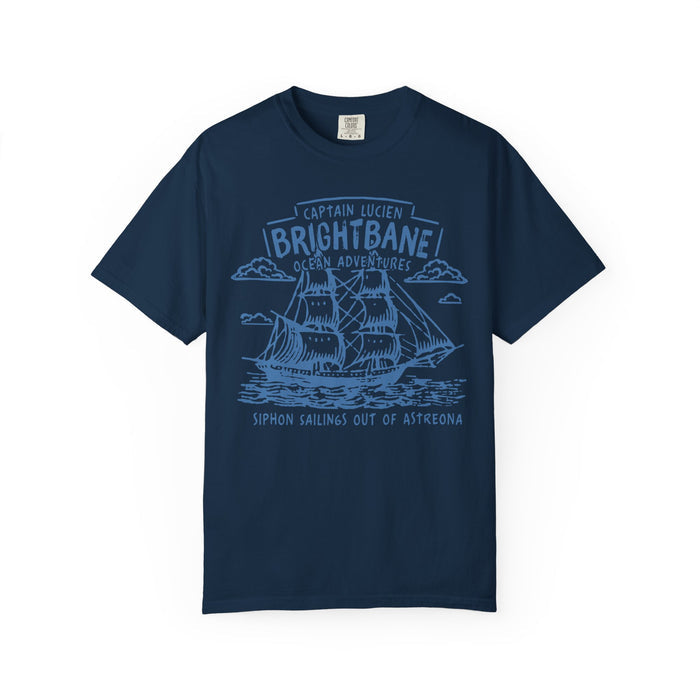 Navy comfort colors graphic tee from thtgrlreads featuring a vintage wash and a detailed light blue sailing ship print with "Captain Lucien Brightbane Ocean Adventure" text, part of Wolves of Ruin collection.