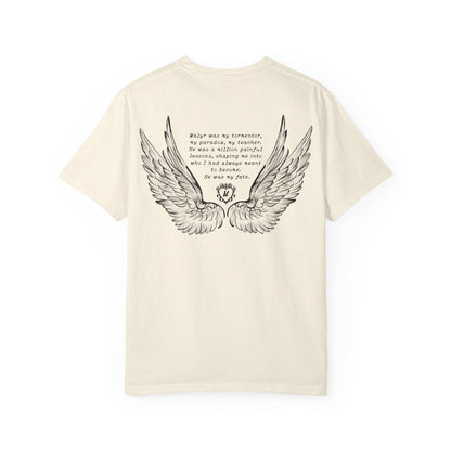Liv Zander collection Comfort Colors graphic tee by thtgrlreads featuring vintage washed cream fabric with black detailed angel wings and poetic text printed on the back, part of Tees collection.