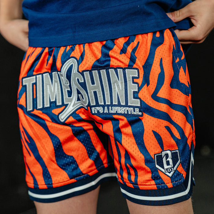 Youth model wearing orange Max Clark Tiger Court youth shorts