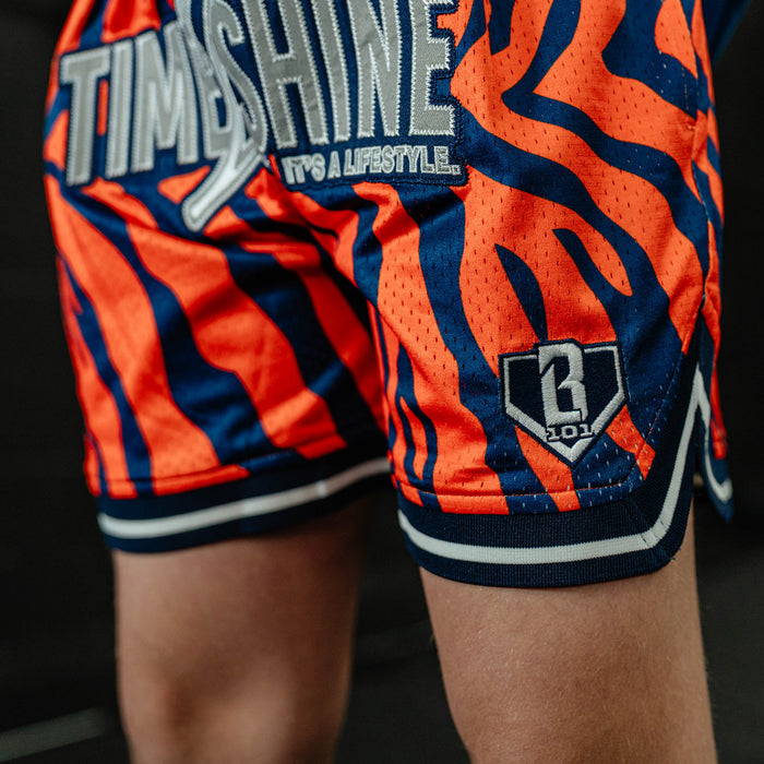 Youth model wearing orange Max Clark Tiger Court youth shorts