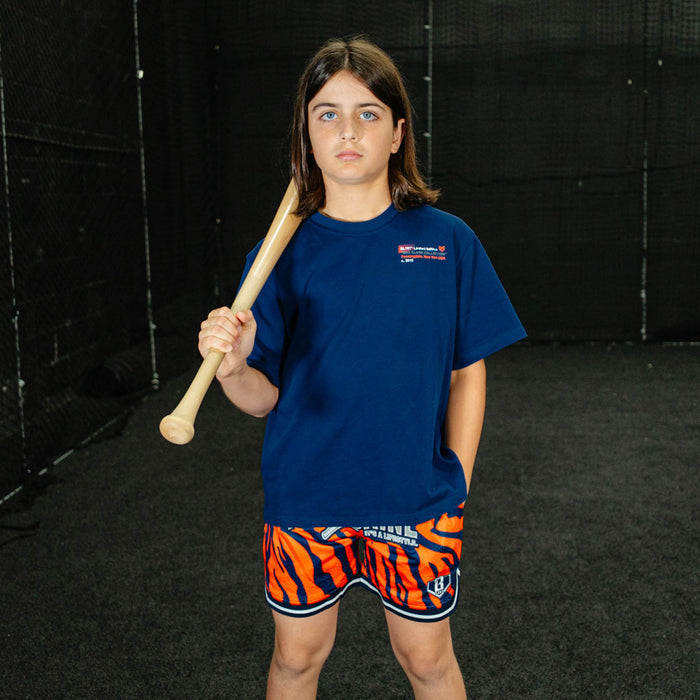 Youth model wearing orange Max Clark Tiger Court youth shorts