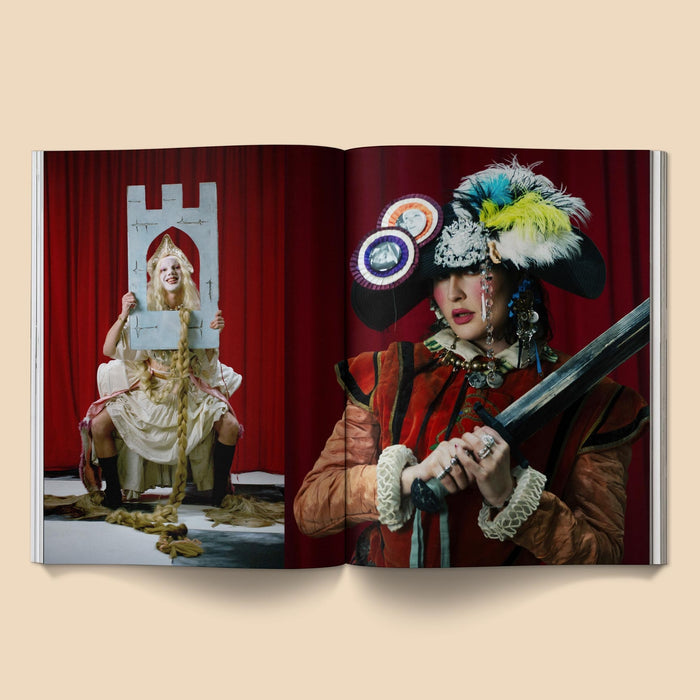 Open magazine spread with two people in elaborate costumes and feathered headwear