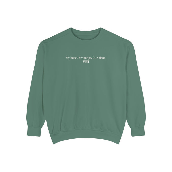 Thtgrlreads oversized crewneck from The Poison Daughter collection featuring a sage green vintage wash Comfort Colors base with white text reading "My heart. My bones. Our blood." in a simple font.