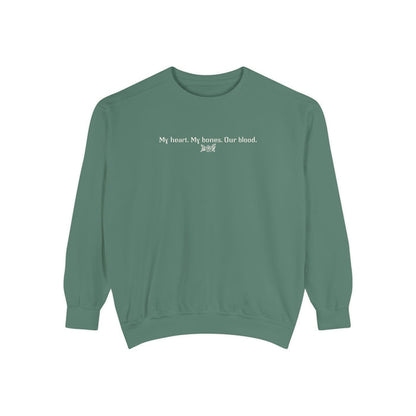 Thtgrlreads oversized crewneck from The Poison Daughter collection featuring a sage green vintage wash Comfort Colors base with white text reading "My heart. My bones. Our blood." in a simple font.
