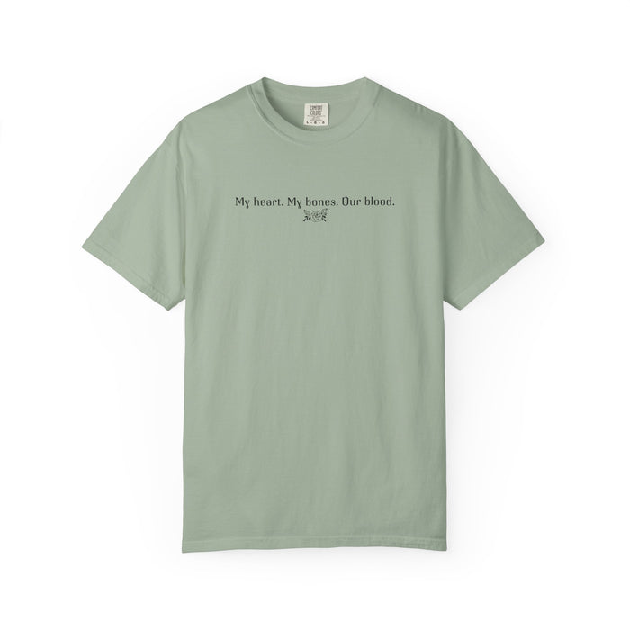 Thtgrlreads officially licensed Comfort Colors graphic tee from The Poison Daughter collection, featuring simple black text "My heart. My bones. Our blood." on a vintage washed sage green fabric.